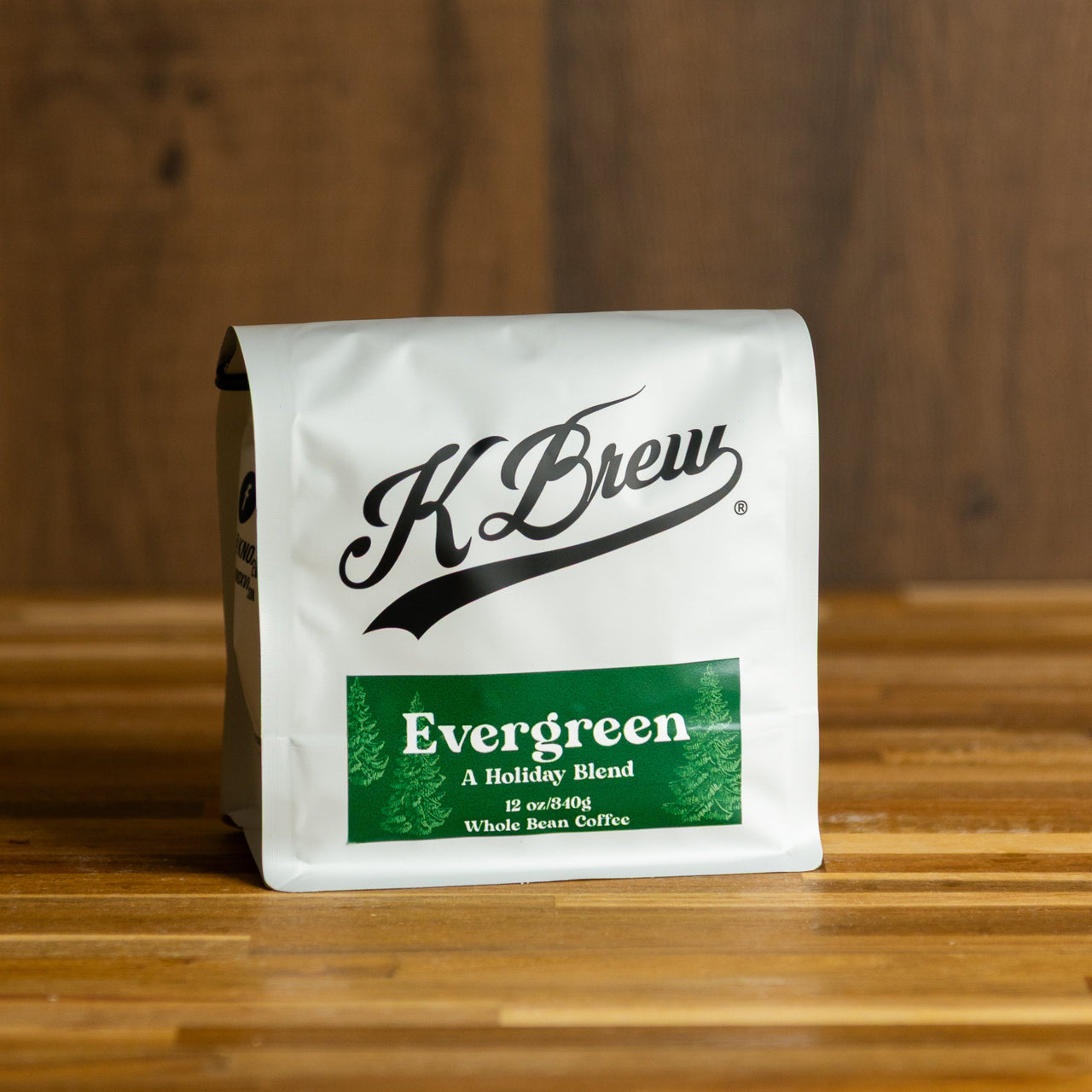 K Brew Evergreen coffee package on a wooden surface with a wooden background